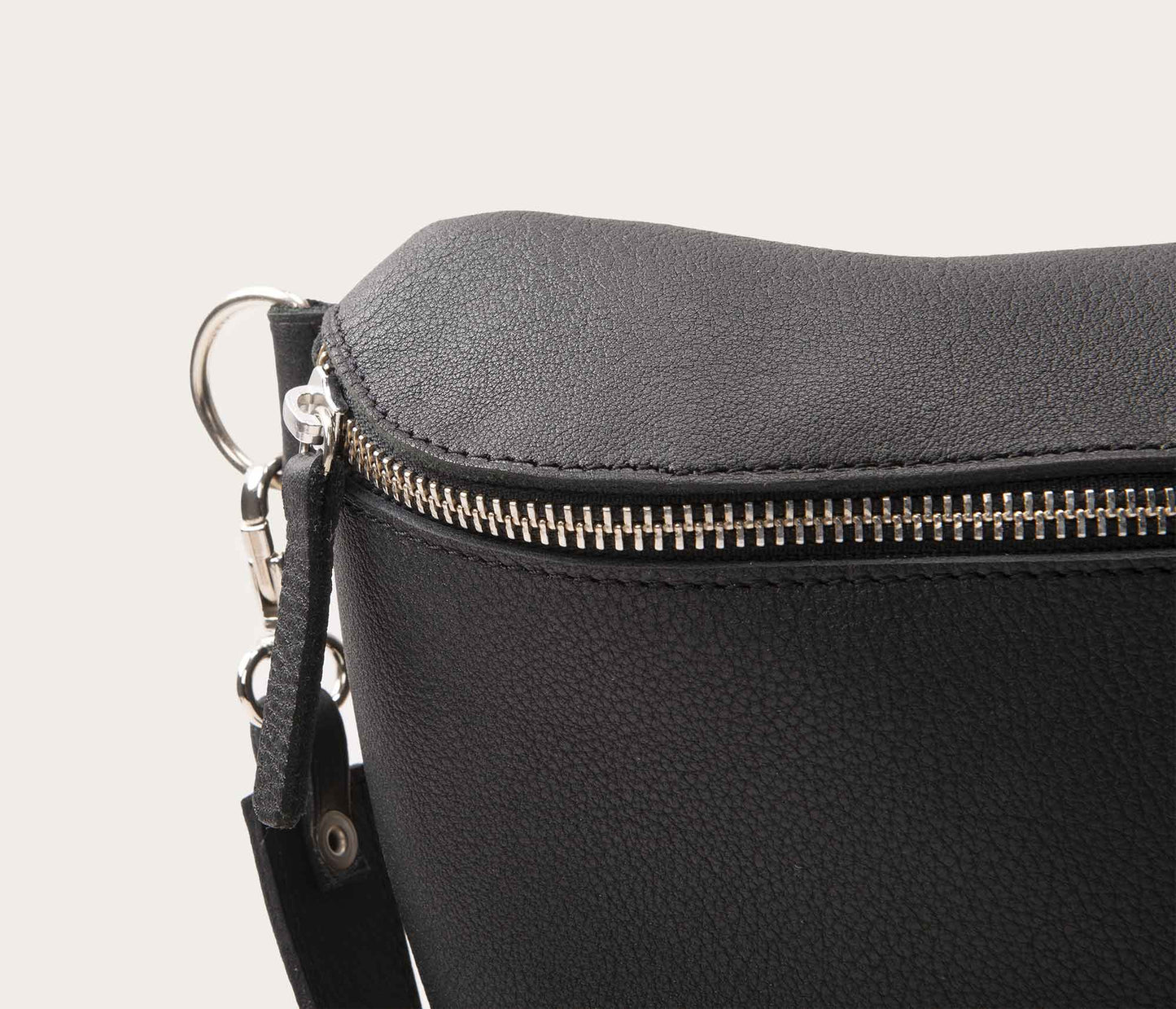 détaildu zip d'un sac banane en cuir noir