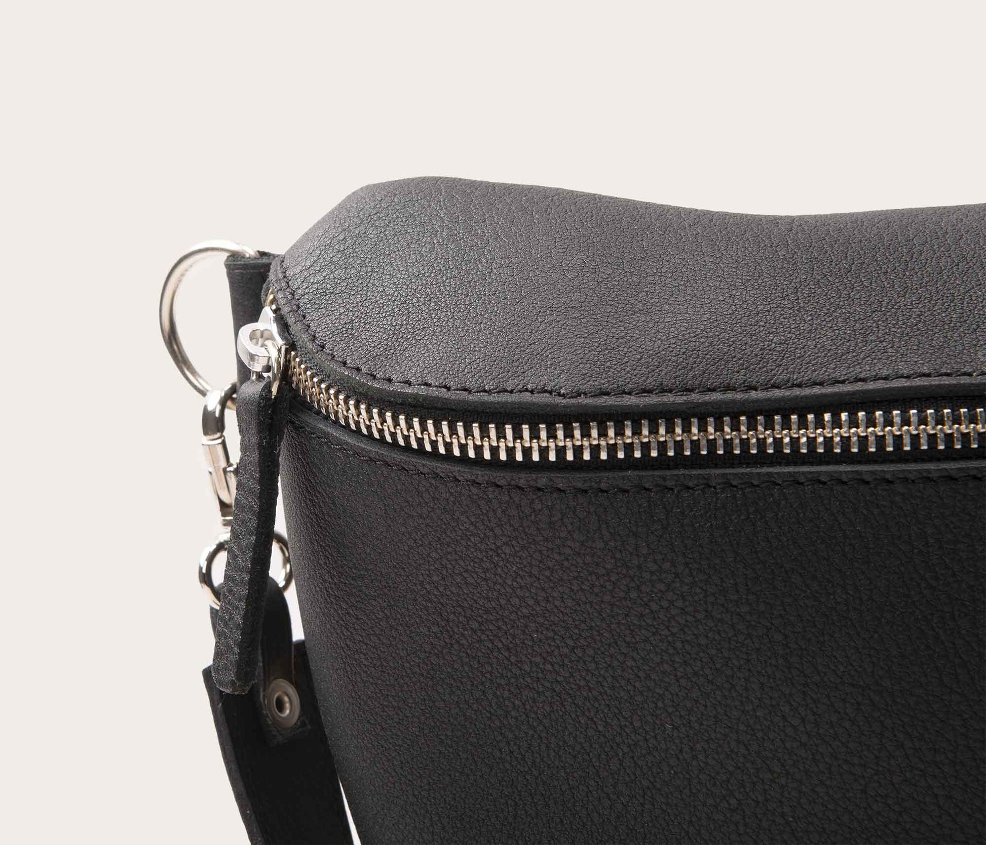 détaildu zip d'un sac banane en cuir noir